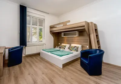 a bedroom with a bunk bed and two blue chairs at Ikar Apartments in Belgrade