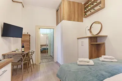 a room with a bed and a table and a kitchen at Ikar Apartments in Belgrade