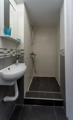 a bathroom with a white sink and a shower at Ikar Apartments in Belgrade