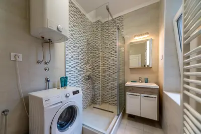 a bathroom with a washing machine and a shower at Ikar Apartments in Belgrade