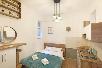 a small bedroom with a bed and a sink at Ikar Apartments in Belgrade