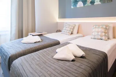 two beds in a hotel room with towels on them at Top Central 5 Apartments in Belgrade