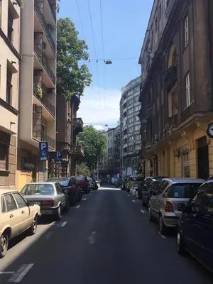 a street with cars parked on the sides of the road at Top Central 5 Apartments in Belgrade