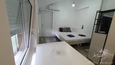 a small white room with a bed and a window at Molders Apartments in Belgrade