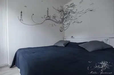 a bedroom with a bed with a tree mural on the wall at Molders Apartments in Belgrade