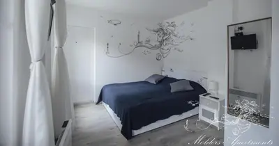 a bedroom with a blue bed and a chandelier at Molders Apartments in Belgrade