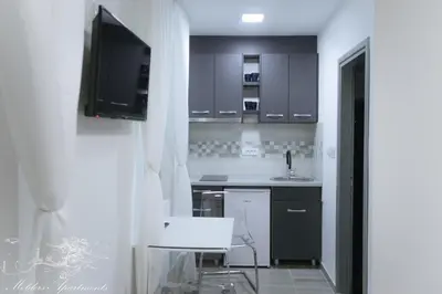 a kitchen with a sink and a tv in a room at Molders Apartments in Belgrade