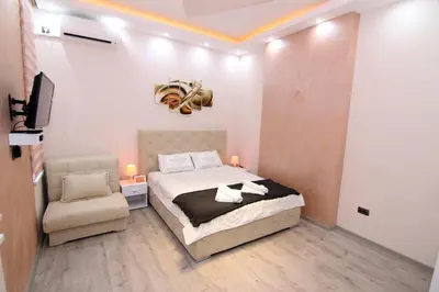 a bedroom with a bed and a chair in it at Lupino Apartments in Belgrade