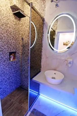 a bathroom with a shower with a sink and a mirror at Lupino Apartments in Belgrade