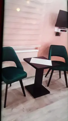 two green chairs and a table in a room at Lupino Apartments in Belgrade