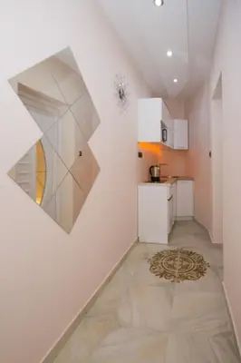a kitchen with white cabinets and a painting on the wall at Lupino Apartments in Belgrade