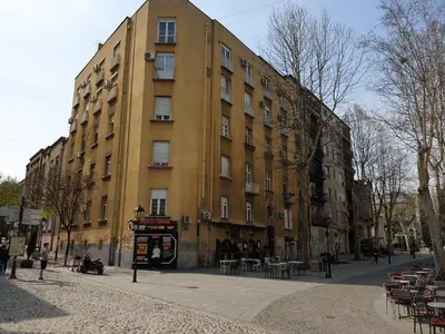 a large yellow building on a city street at Lupino Apartments in Belgrade