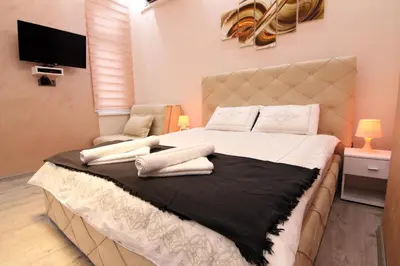 a bedroom with a large bed with white pillows at Lupino Apartments in Belgrade