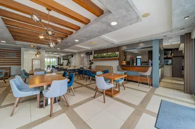 a dining room with tables and blue chairs at Hotel Garni VIZURA Sport in Belgrade