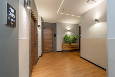 a hallway with a door and a potted plant at Hotel Garni VIZURA Sport in Belgrade