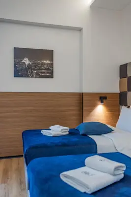two beds in a hotel room with towels on them at Hotel Garni VIZURA Sport in Belgrade