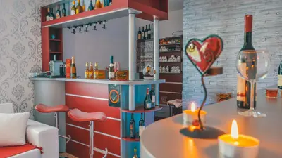 a bar with a table with a candle and a bottle of wine at MK Star Boutique Hotel in Belgrade