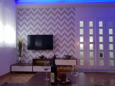 a living room with two wine glasses and a television at Apartment Nikola Tesla in Belgrade