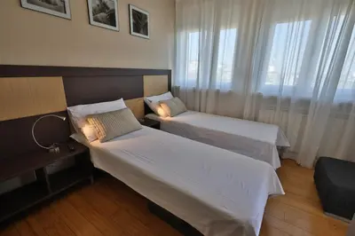 a hotel room with two beds and a window at Business & Travel Apartments in Belgrade