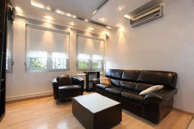 a living room with a leather couch and a table at Business & Travel Apartments in Belgrade