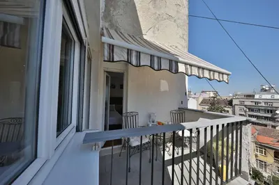 a balcony with a table and chairs on a building at Business & Travel Apartments in Belgrade