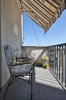 a patio with a table and a chair on a balcony at Business & Travel Apartments in Belgrade