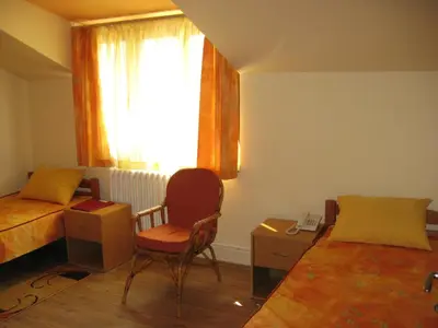 a bedroom with a bed and a chair and a window at Hostel Oasis in Belgrade