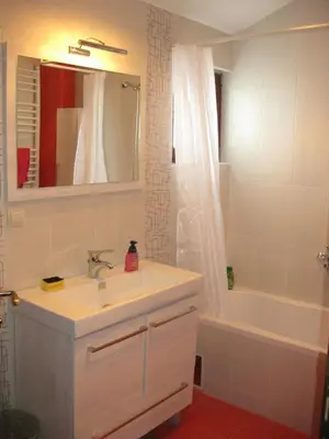 a bathroom with a sink and a tub and a mirror at Hostel Oasis in Belgrade