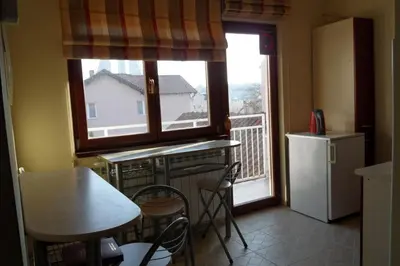 a kitchen with a window and a table and a refrigerator at Hostel Oasis in Belgrade