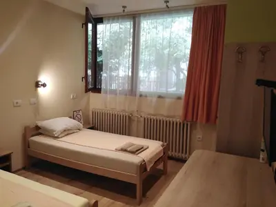 a small room with two beds and a window at Hostel Oasis in Belgrade