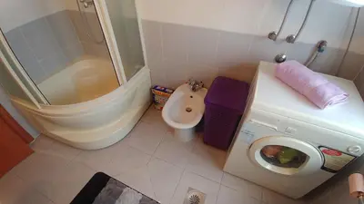 a bathroom with a toilet a sink and a washing machine at Talas apartmani in Belgrade