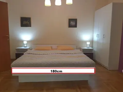 a bedroom with a large bed with two night stands at Talas apartmani in Belgrade