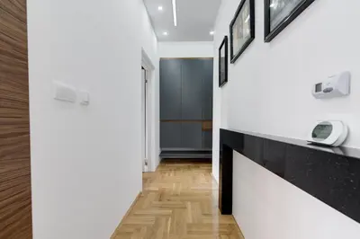 a hallway with black and white walls and wood floors at CENTAR President in Arandjelovac