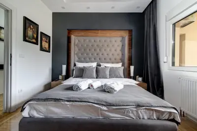 a bedroom with a large bed with two towels on it at CENTAR President in Arandjelovac