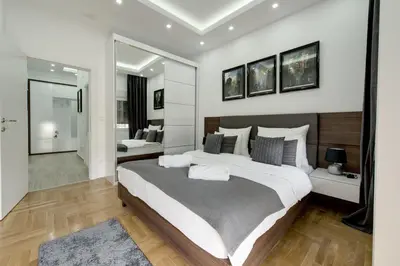 a bedroom with a large bed and a mirror at CENTAR President in Arandjelovac