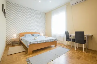 a bedroom with a bed and a table and chairs at Belgrade Center Apartment Skadarlija in Belgrade