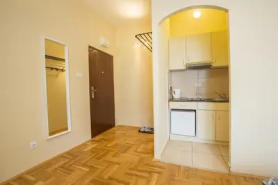 a kitchen with white cabinets and a wooden floor at Belgrade Center Apartment Skadarlija in Belgrade