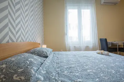 a bedroom with a bed with a blue blanket and a window at Belgrade Center Apartment Skadarlija in Belgrade