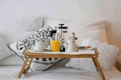 a wooden tray with a breakfast on a bed at Danube Pearl in Belgrade