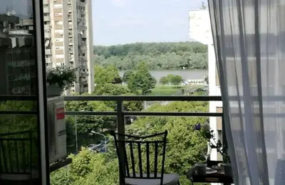 a balcony with a chair and a view of a river at Danube Pearl in Belgrade