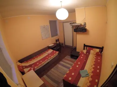 a small room with two beds and a table at Hostel Respect in Pančevo