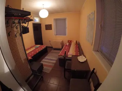 a room with two beds and a table and chairs at Hostel Respect in Pančevo