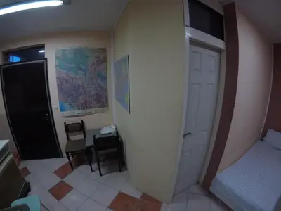 a bedroom with a bed and a door and a chair at Hostel Respect in Pančevo