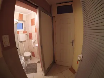 a bathroom with a toilet and a white door at Hostel Respect in Pančevo