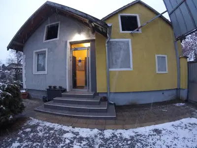 a yellow and gray house with stairs and a door at Hostel Respect in Pančevo