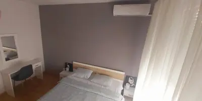 a small bedroom with a bed and a window at Apartman Metropol Belville in Belgrade