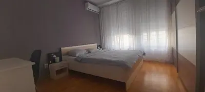 a small bedroom with a bed and a window at Apartman Metropol Belville in Belgrade