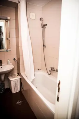a bathroom with a bath tub and a sink at Apartman Metropol Belville in Belgrade
