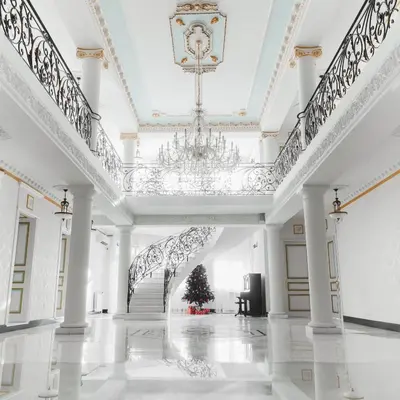 a white hall with a christmas tree and a chandelier at Hotel Jardin in Belgrade