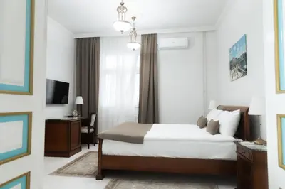 a bedroom with a bed and a desk and a window at Hotel Jardin in Belgrade